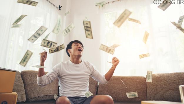 homem-feliz-com-dinheiro-dolares-voando-no-escritorio-em-casa